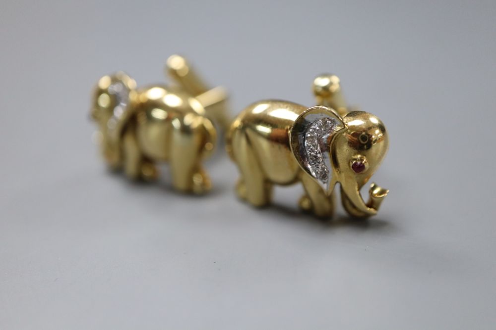 A pair of modern yellow metal (stamped 750), diamond and cabochon ruby set elephant cufflinks, 20mm, gross 14 grams.